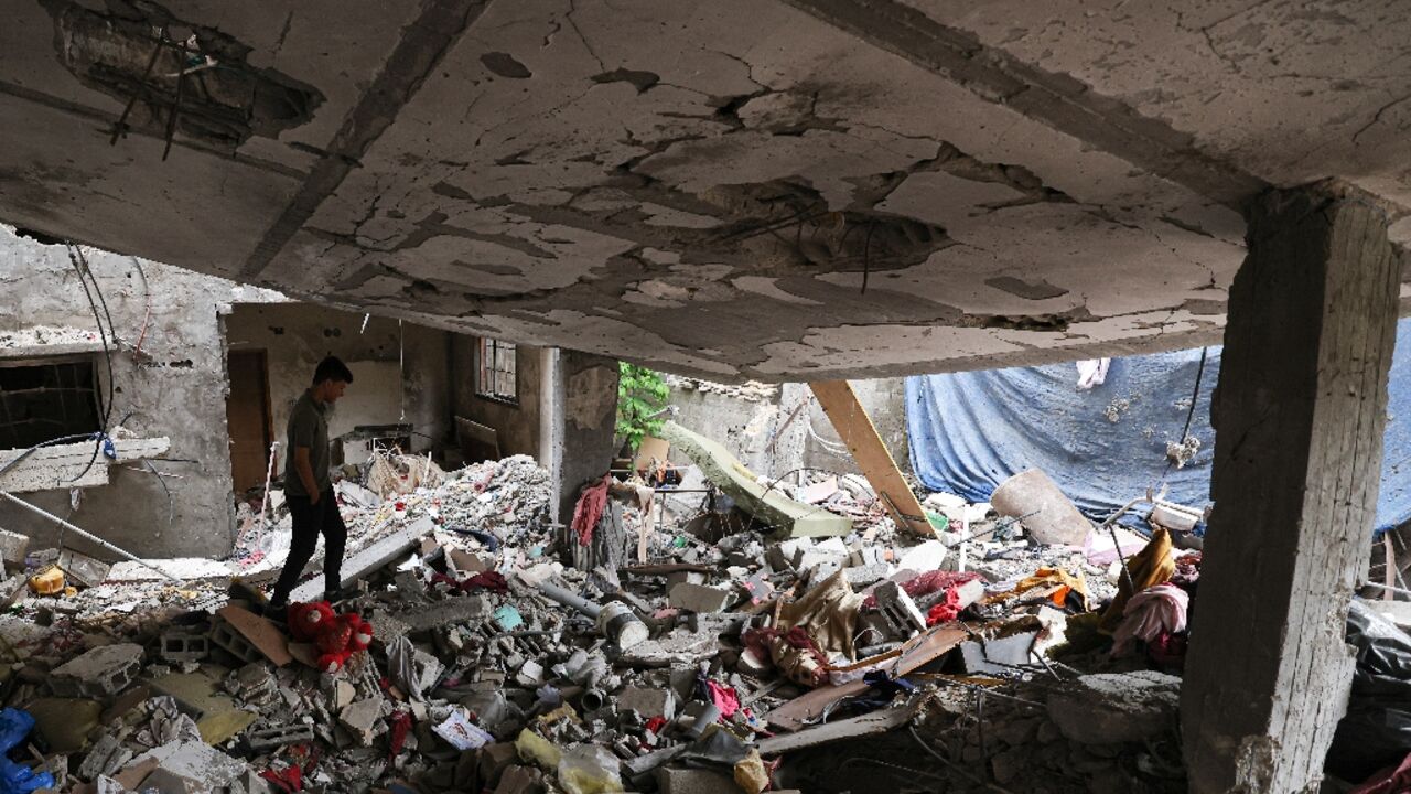 A Palestinian man walks in his destroyed house in Gaza City which was hit during the latest round of fighting between Gaza militants and the Israeli army