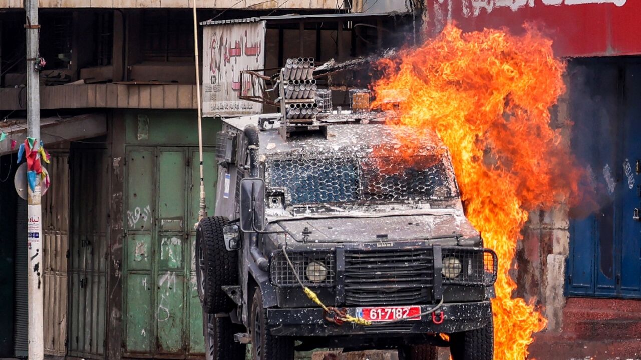 A Molotov cocktail explodes on an Israeli armoured vehicle during an army raid in Nablus