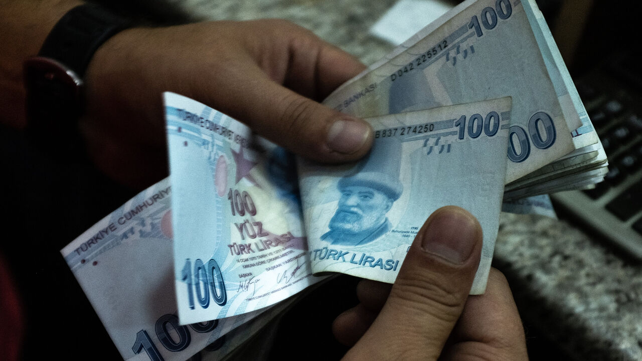 A man counts Turkish liras at a currency exchange office, Istanbul, Turkey, July 29, 2020.