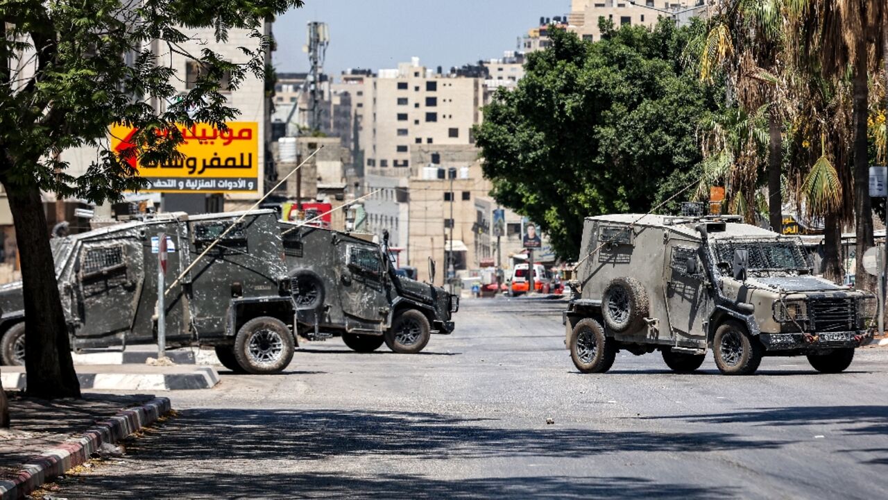 Israeli army vehicles block off a road during a deadly raid on a Palestinian refugee camp in the flashpoint West Bank city of Nablus