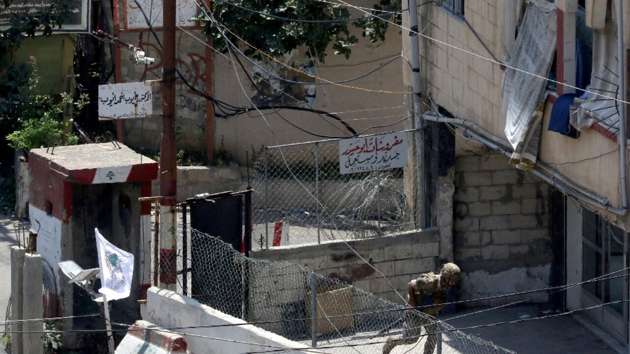 A Lebanese soldier takes cover at the entrance to Ain al-Helweh