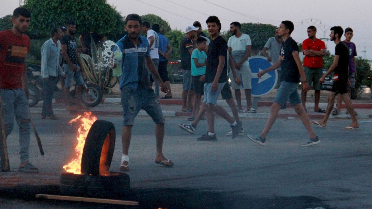 Tunisian youths block a road and set tyres on fire amid hih tensions in Sfax on July 4, 2023 after the burial of a young Tunisian stabbed to death during a scuffle between residents and migrants from sub-Saharan Africa 