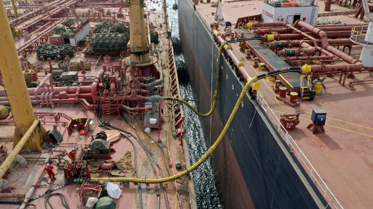 Workers prepare to transfer oil  from the 47-year-old supertanker FSO Safer (L) to a UN-purchased replacement vessel in a bid to avert a catastrophic spill in the Red Sea off war-torn Yemen