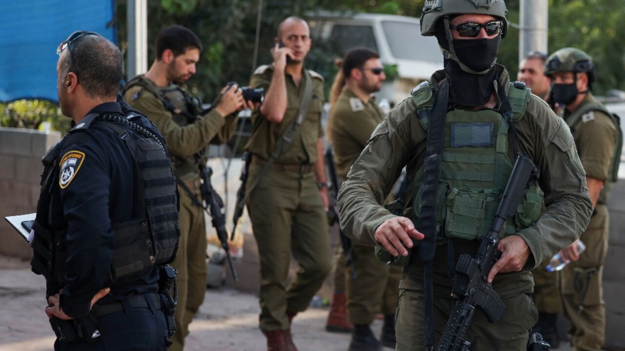 Israeli security forces stand guard at the car wash in the West Bank town of Huwara where two Israeli civilians were shot dead in an attack