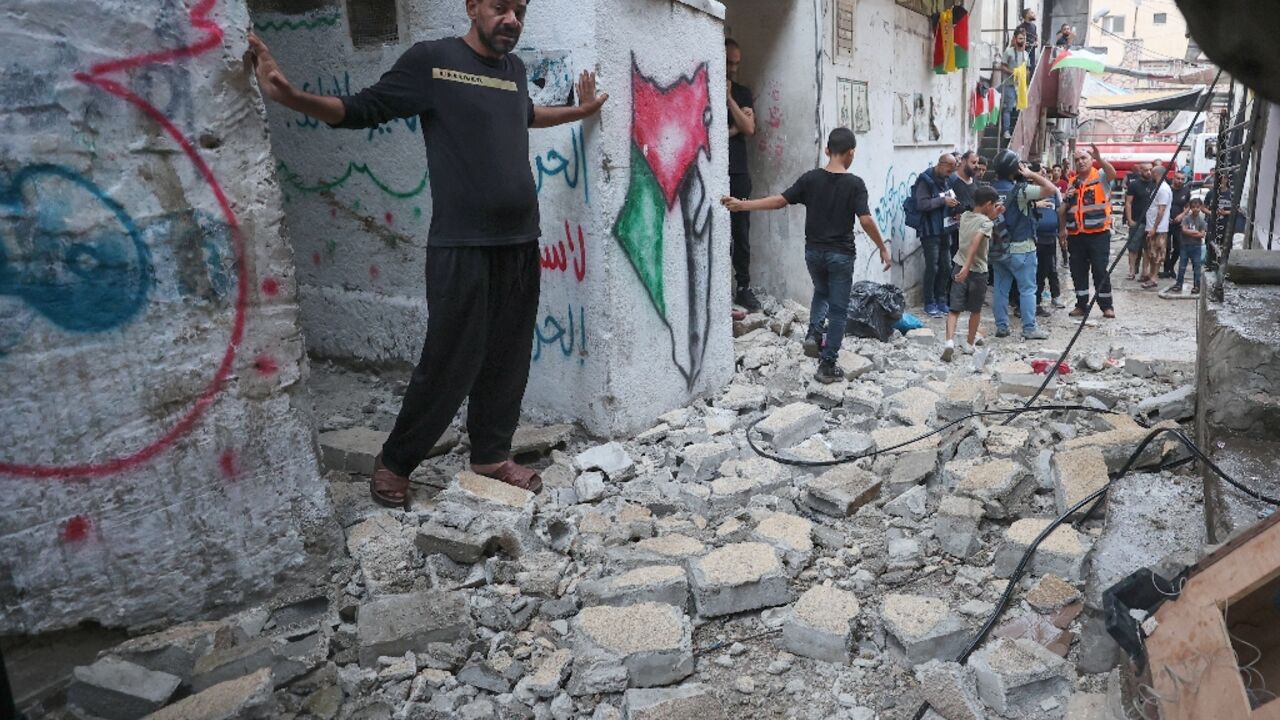 Palestinian emergency personnel and residents inspect the damage following the Israeli raid on Balata refugee camp in the occupied West Bank