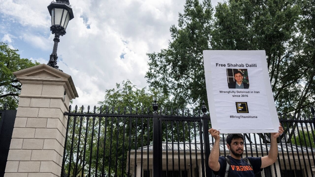 Darian Dalili holds up a sign as he holds a hunger strike outside the White House to call for the release of his father, Shahab Dalili, a US permanent resident held in an Iranian prison since 2016