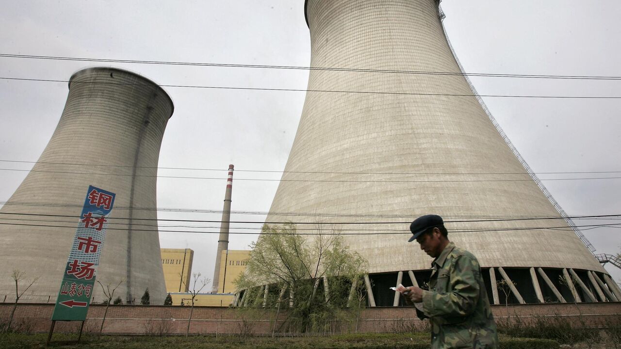 A man walks past a power station on the outskirts of Beijing, April 7, 2005.  