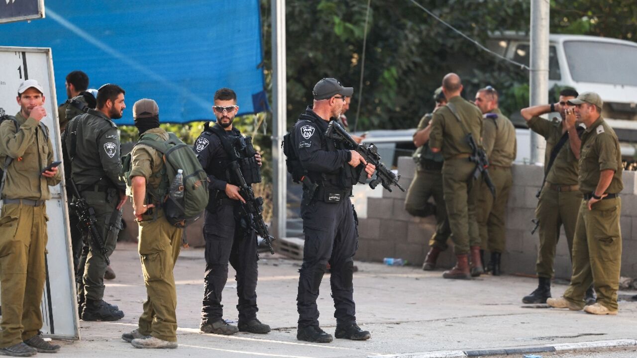 Israeli security forces stand guard at the site of Saturday's attack in the town of Huwara in the occupied West Bank