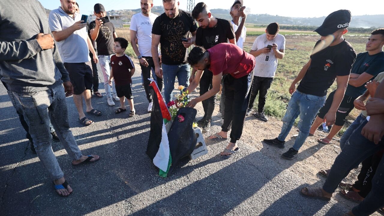 Mourners lay roses at the site where three Palestinians were killed by Israeli forces near Jenin camp in the occupied West Bank