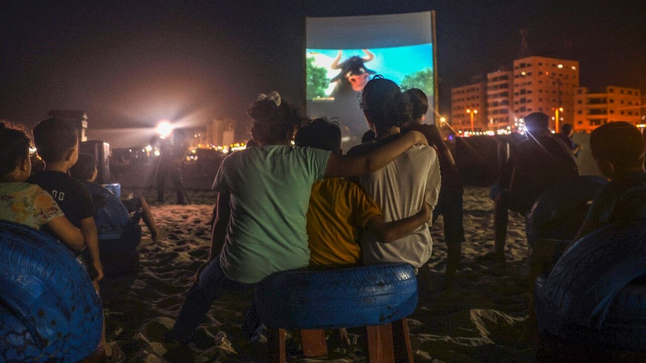 Palestinian children watch a film at a pop-up open-air cinema in Gaza city