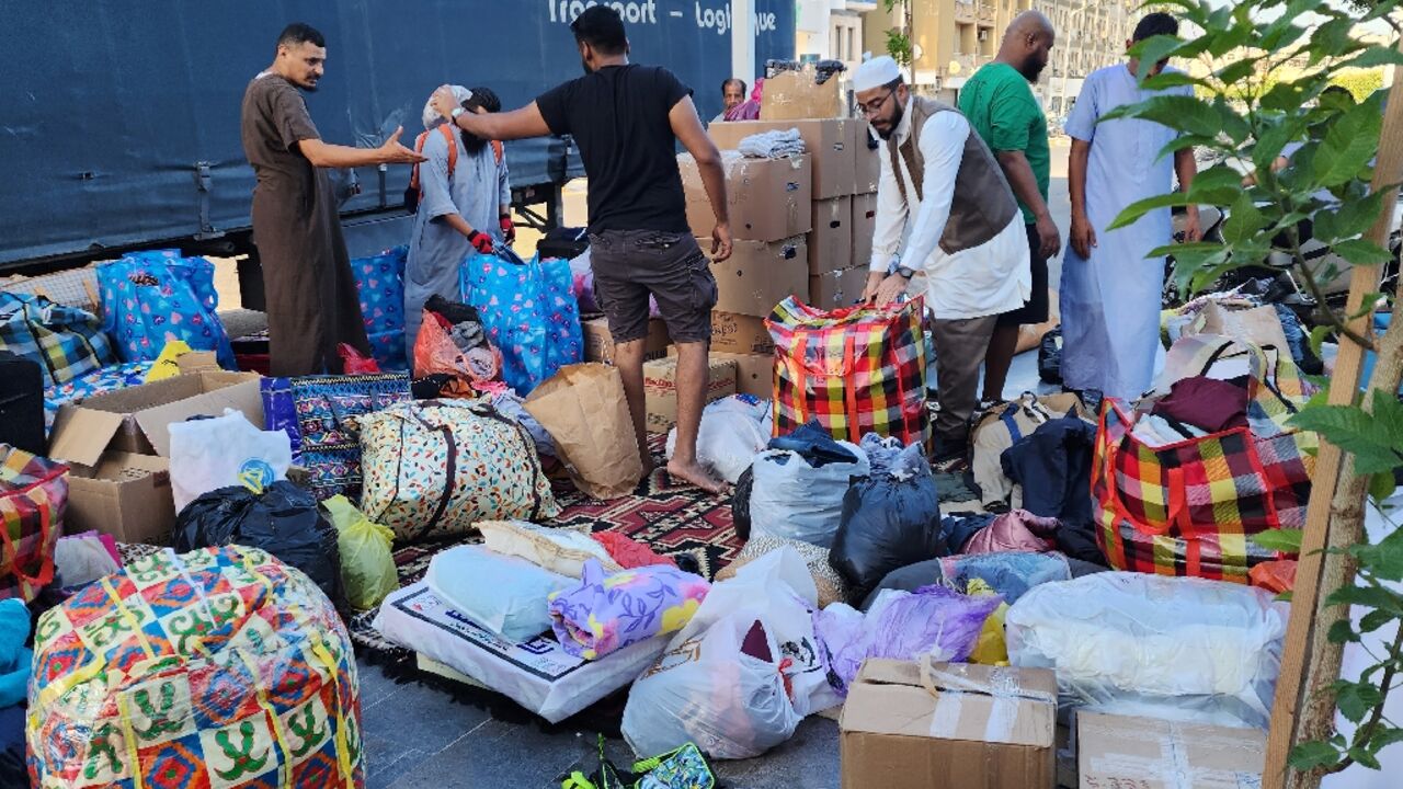 Libyans donate clothes and blankets at a collection point in the capital Tripoli for transport across the nation's political divide to the flood-hit city of Derna