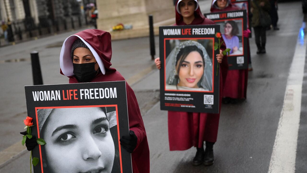 Demonstrators hold placards reading "Women, Life, Freedom" as they demonstrate against the persecution of women in Iran, on Whitehall in central London on March 8, 2023. 