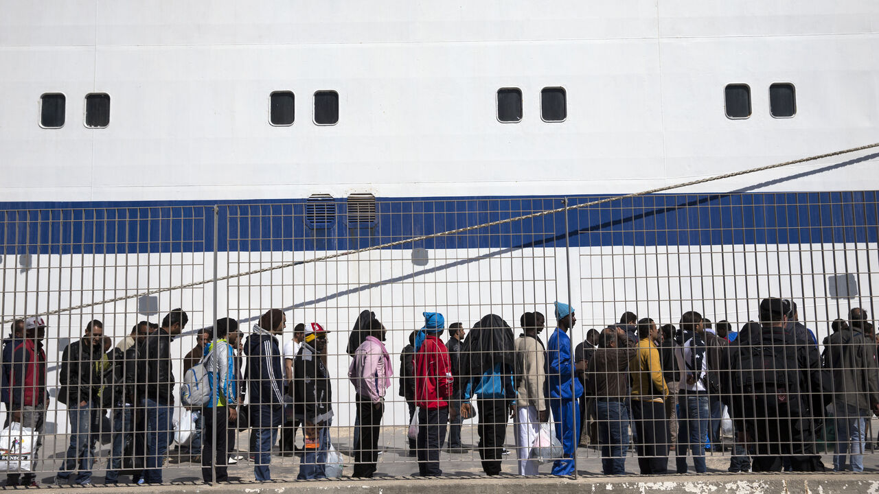 Migrant men wait to board a ship bound for Sicily from Lampedusa, Italy, April 22, 2015. 