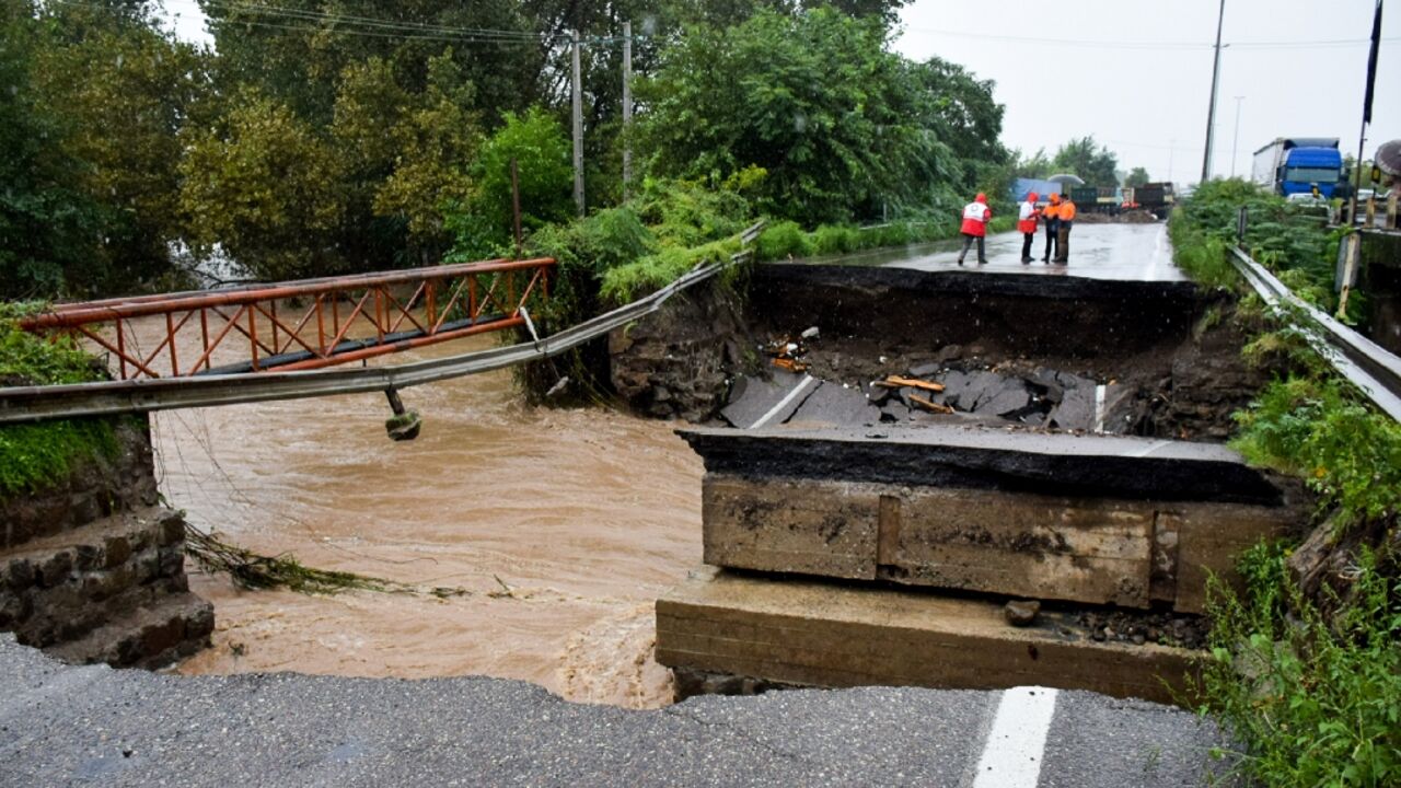 Emergency services survey a collapsed road bridge in the Iranian city of Astara after the area is hit by what officials describe as the heaviest rainfall in a century