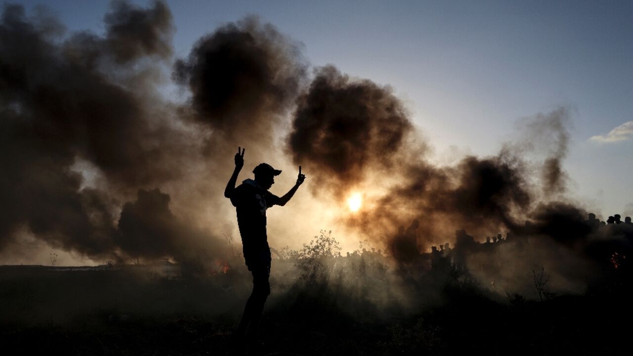 Palestinian demonstrators burn tyres during clashes with Israeli soldiers along the Gaza-Israel border