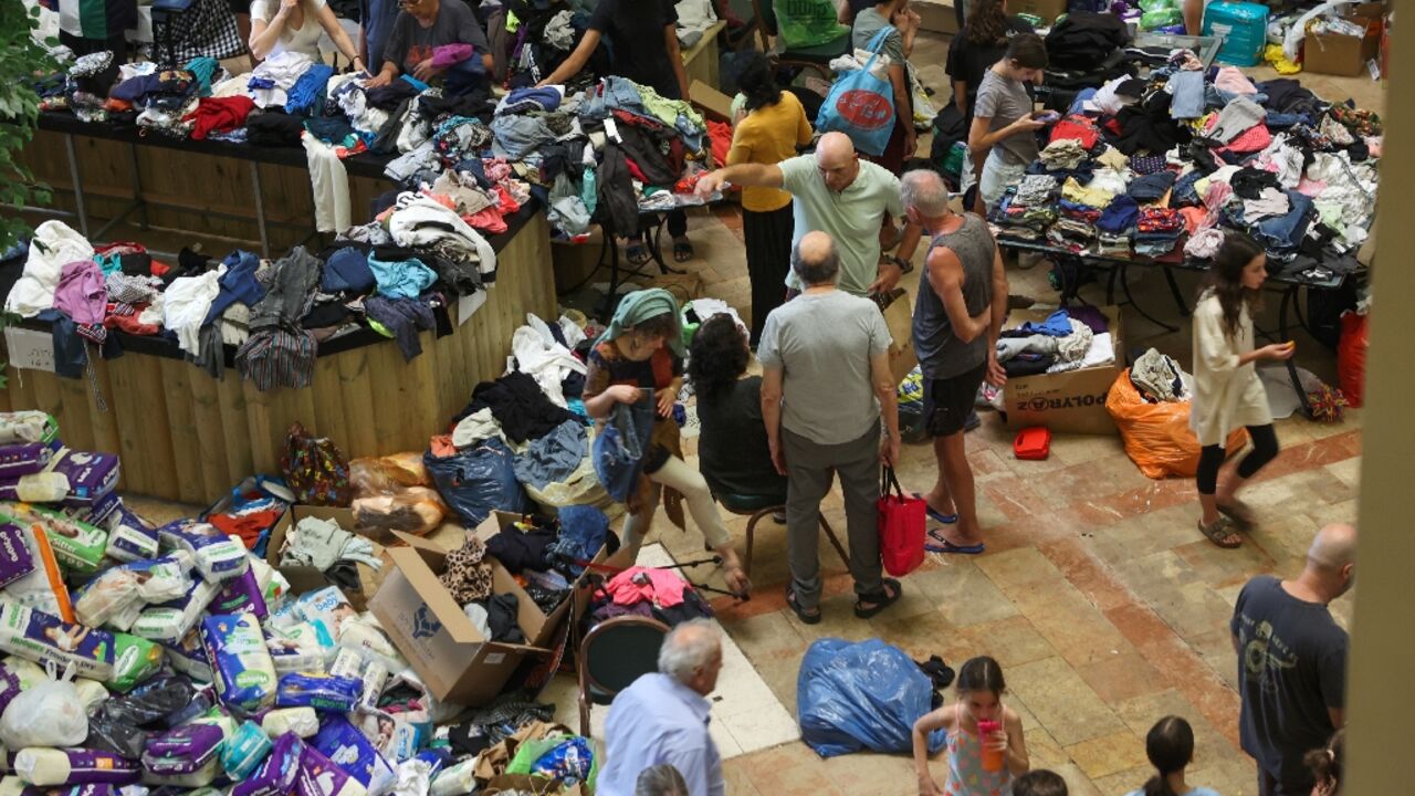 Israeli evacuees from kibbutzim near the Gaza border receive clothing donations at a hotel in the Dead Sea area