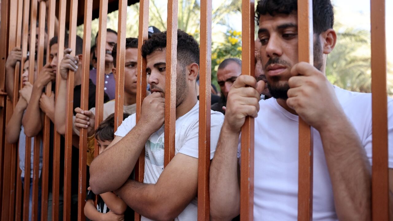 Palestinians wait outside the Nasser hospital to claim the bodies of relatives