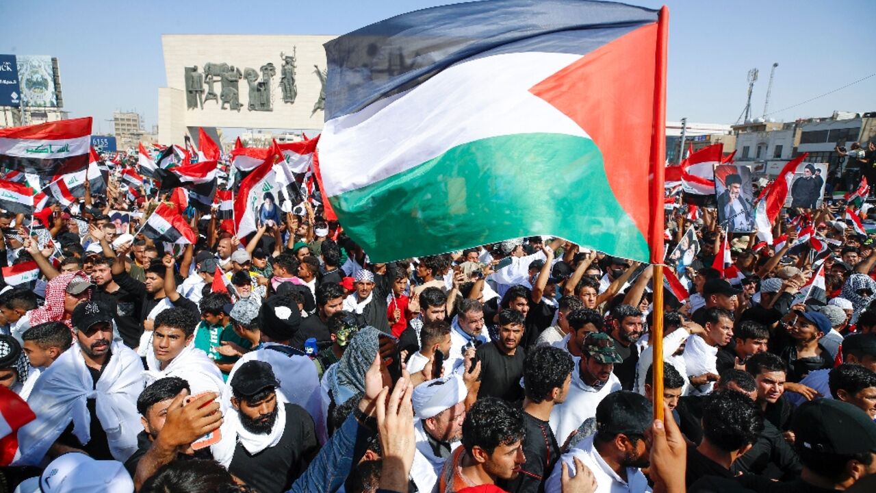 Protesters wave a Palestinian flag at a rally in Baghdad's Tahrir Square on October 13