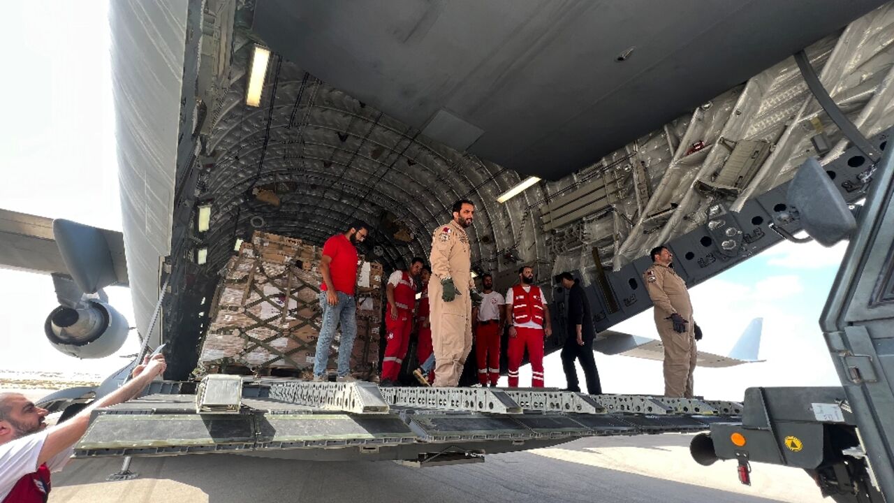 Volunteers from Qatar and Egypt's Red Crescent unload aid destined for the Gaza Strip at Egypt's El Arish airport