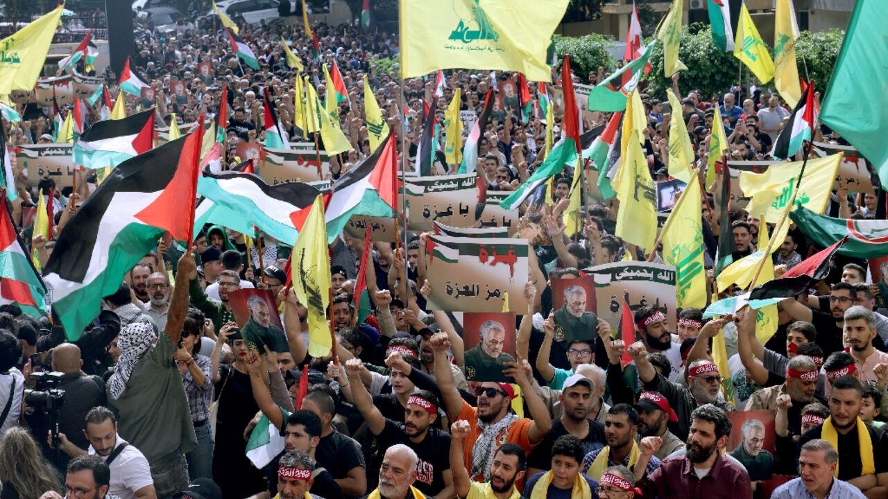 Hezbollah supporters wave the Palestinian flag alongside their movement's yellow emblem at a solidarity rally in Beirut