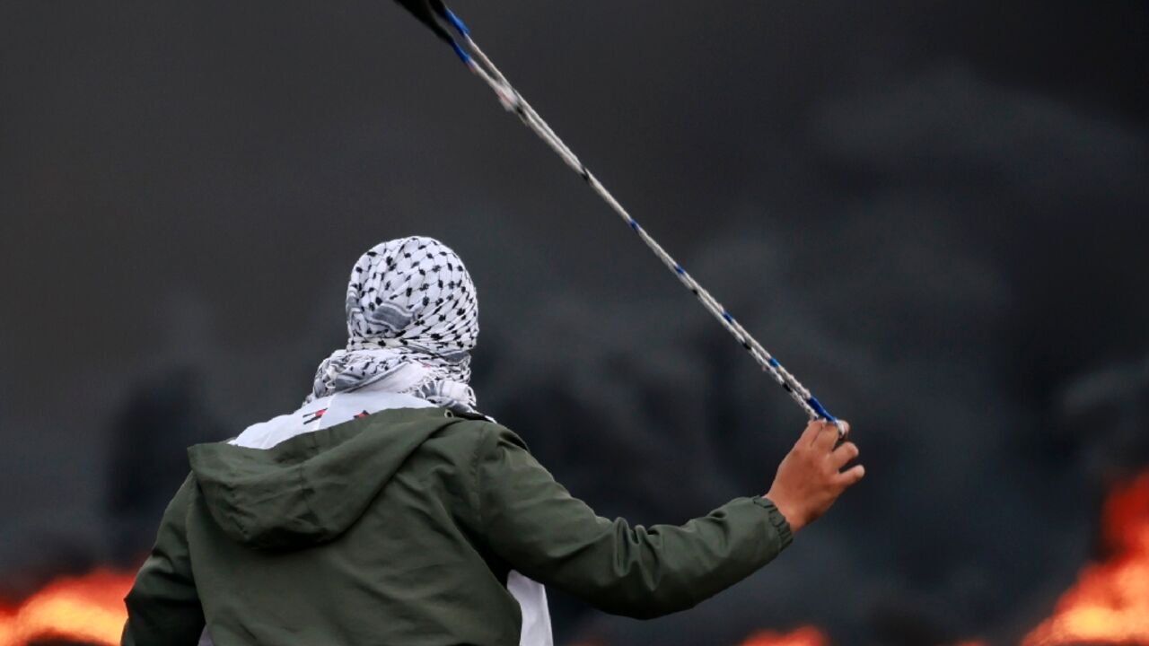 A Palestinian hurls stones at Israeli forces during a demonstration against the Israli bombardment of the Gaza Strip, in the city of Ramallah in the occupied West Bank on October 11, 2023