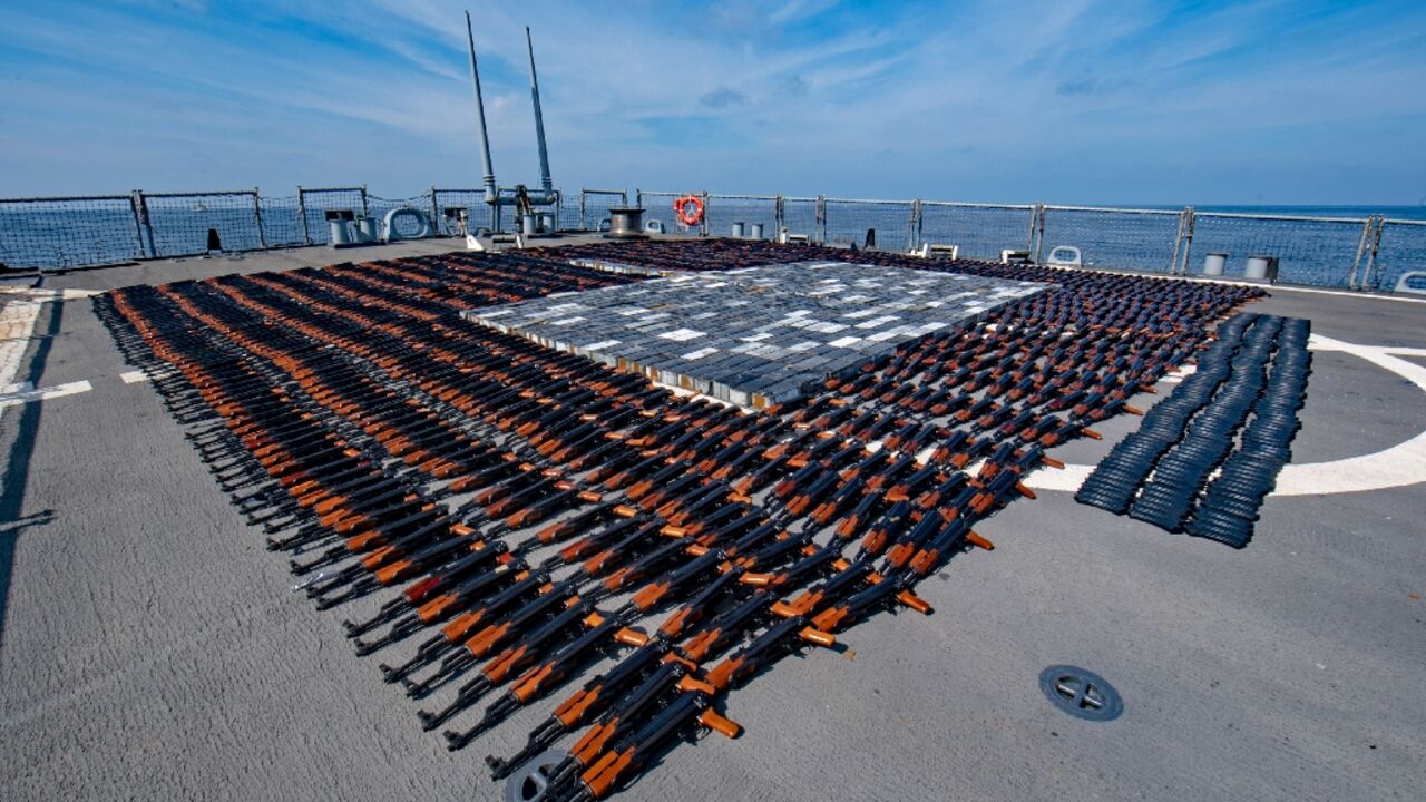 A handout photo released on December 22, 2021 by the US Defense Department shows AK-47 rifles and ammunition seized by the US navy from a fishing boat in the North Arabian Sea
