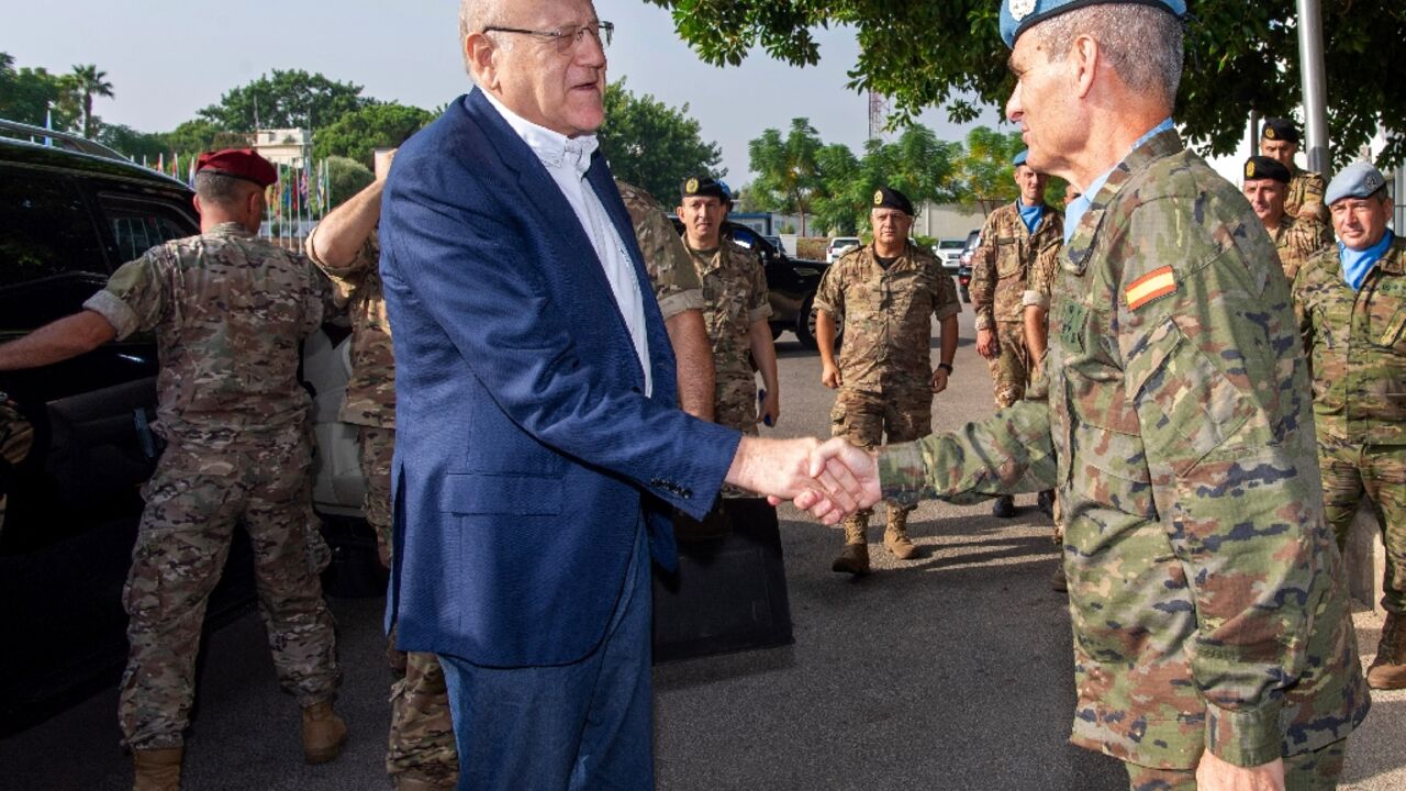 Lebanon's Najib Mikati (L) shaking hands with UNIFIL chief Aroldo Lazaro in southern Lebanon near the Israeli border