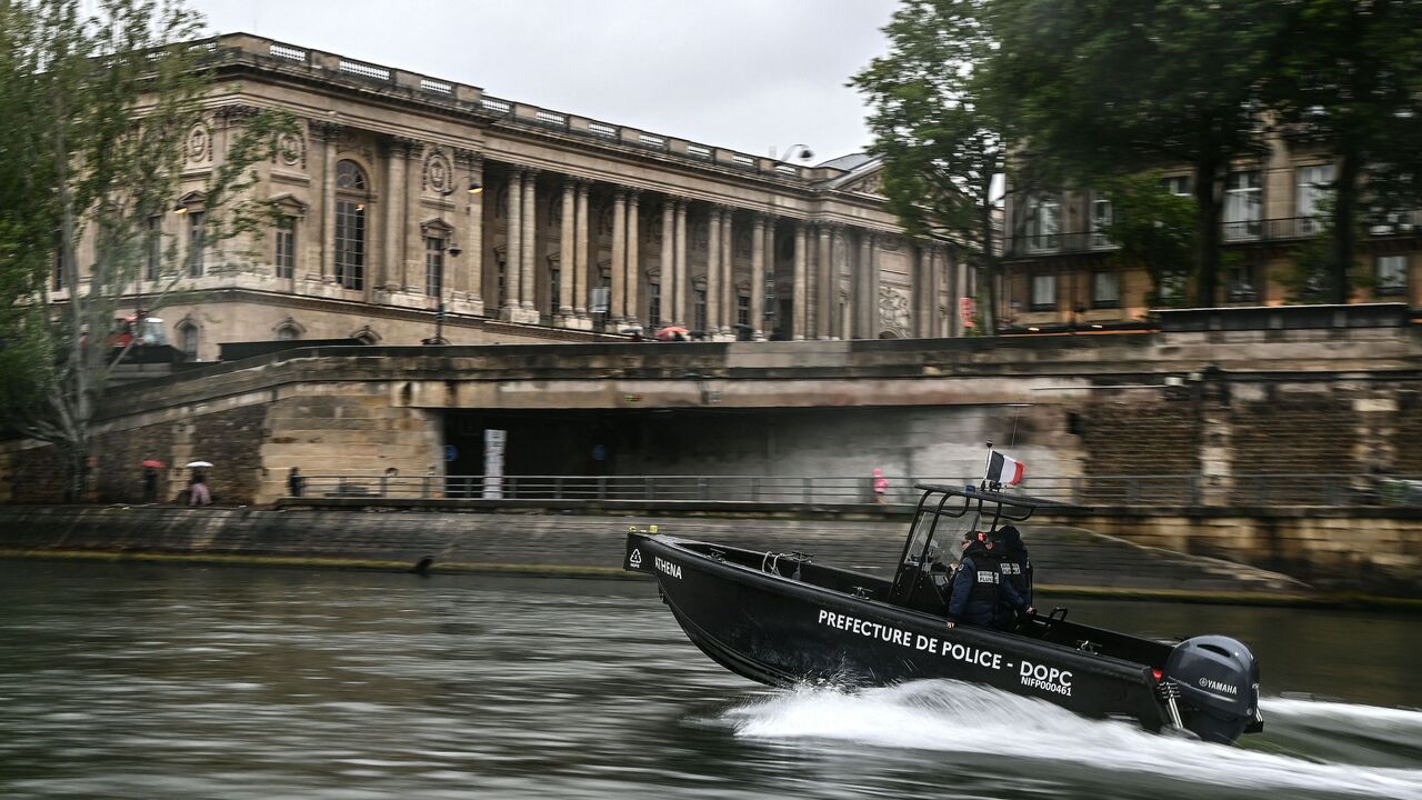 Policemen from the River Brigade (Brigade Fluviale) patrol on a boat on the Seine River, in front of the Louvres' museum in Paris on May 9, 2023.