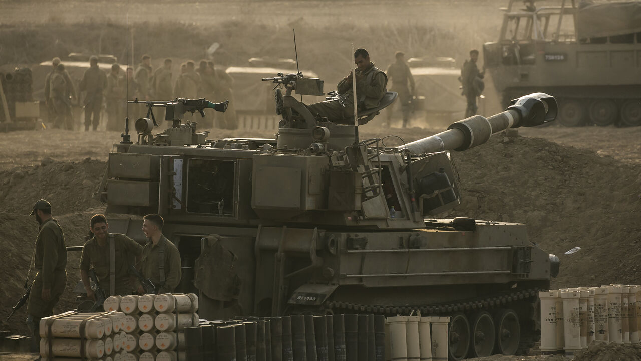 Soldiers sit on an artillery unity near the Israeli border with the Gaza Strip, in Netivot, Israel, Oct. 22, 2023.