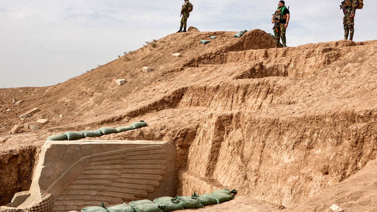 Iraqi security forces stand guard at the site of a newly-unearthed Assyrian Lamassu (human-headed winged bull) sculpture discovered with its entire wings intact by the French archaeological mission at the archaeological site of Khorsabad (also known as Dur-Sharrukin), the former Assyrian capital in the time of Sargon II (721705 BC) in Iraq's northern Nineveh province on October 24, 2023. (Photo by Zaid AL-OBEIDI / AFP) (Photo by ZAID AL-OBEIDI/AFP via Getty Images)