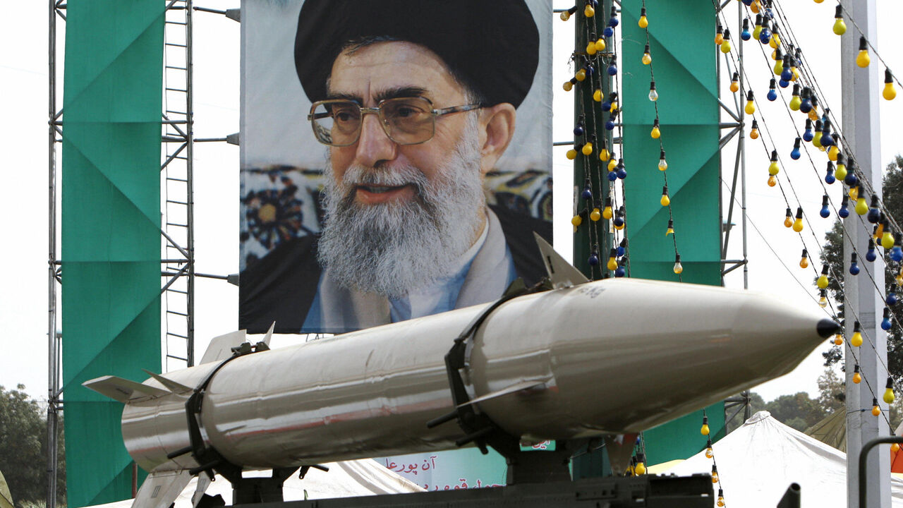 An Iranian missile stands on display in front of a large portrait of Iran's supreme leader, Ayatollah Ali Khamenei, in a square in south Tehran, Sept. 28, 2008.