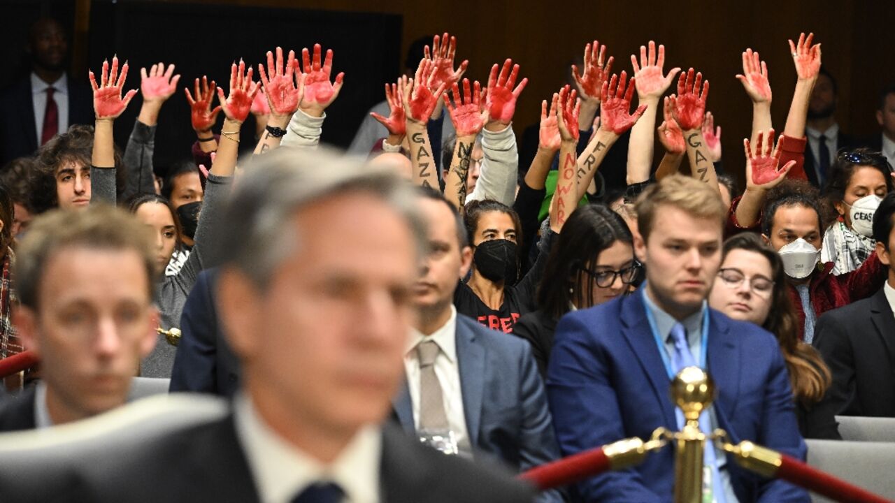 Protesters raise their painted hands as US Secretary of State Antony Blinken testifies during a Senate Appropriations Committee hearing to examine the national security supplemental request, in Washingotn October 31, 2023