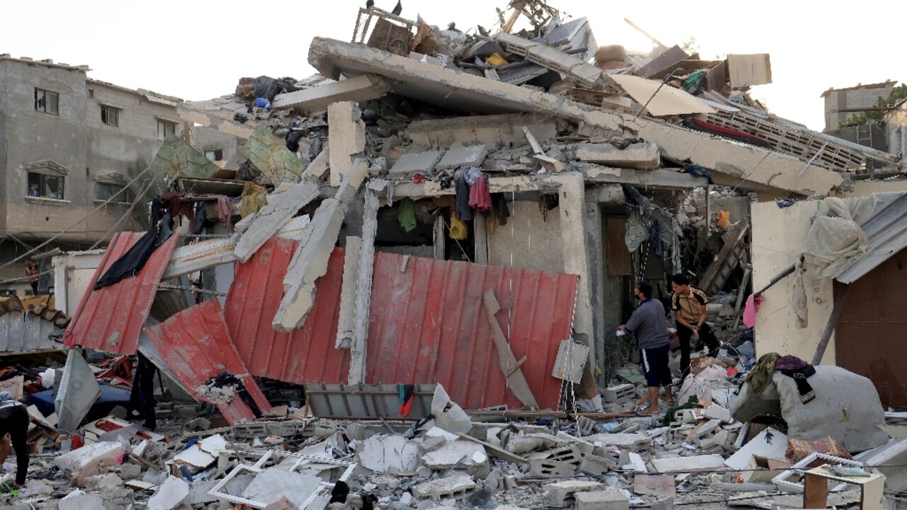 Palestinians look through the rubble of a building following an Israeli bombardment of Khan Yunis in southern Gaza