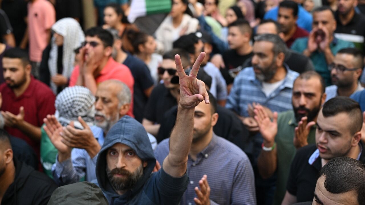 A Palestinian man flashes the victory sign during a demonstration in Ramallah in the occupied West Bank on October 18, 2023, protesting a strike on a Gaza hospital which killed hundreds a day earlier