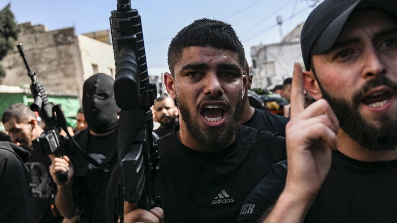 Armed Palestinians join the funeral procession for three militants killed in an overnight raid by the Israeli army on Jenin refugee camp in the occupied West Bank