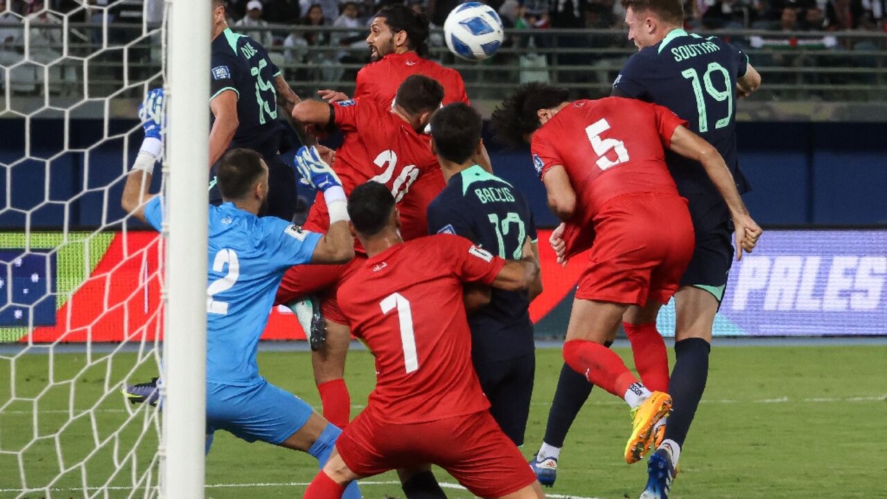 Australia's Harry Souttar (R) scores against Palestine in a 2026 FIFA World Cup AFC qualifier at Jaber Al-Ahmad International Stadium in Kuwait City