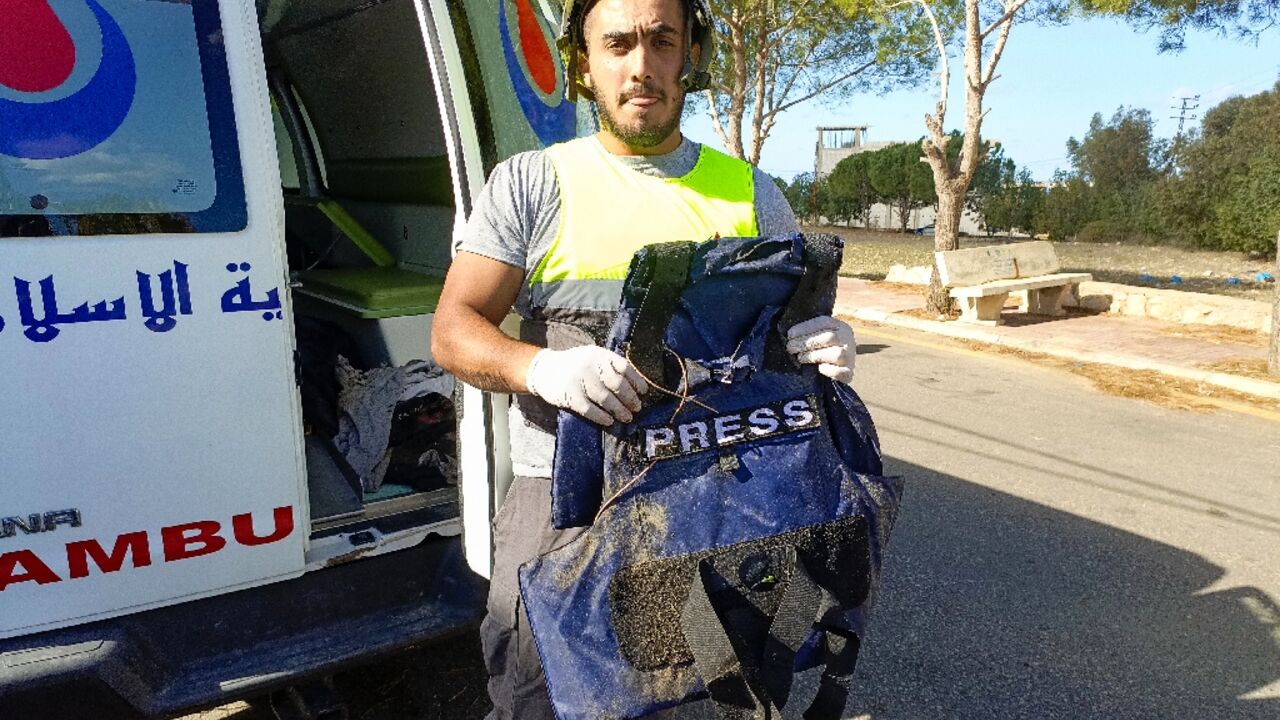 A Lebanese rescuer holds the bullet proof vest of one of two journalists working for Al-Mayadeen television killed in Israeli bombardment of southern Lebanon