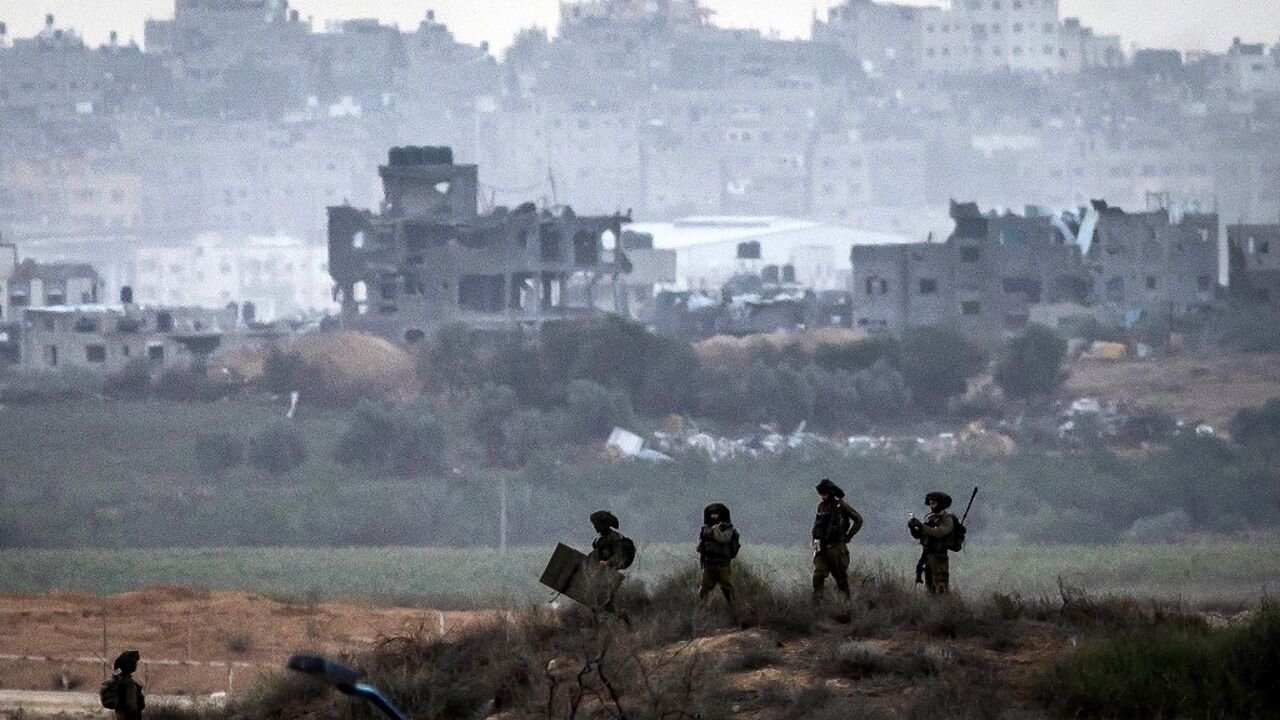 This picture taken from a position along the border with the Gaza Strip in southern Israel shows Israeli soldiers amid ongoing battles with the Palestinian militant group Hamas, on November 14, 2023
