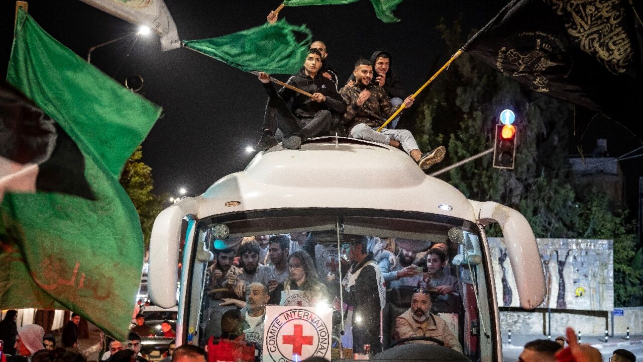 A crowd surrounds a Red Cross bus carrying Palestinian prisoners released from Israeli jails in exchange for hostages released by Hamas from the Gaza Strip, in Ramallah in the occupied West Bank