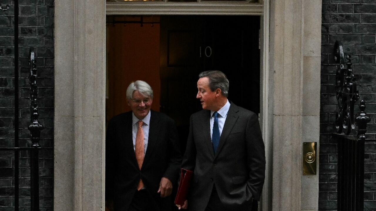 UK Foreign Secretary David Cameron (R) and development minister Andrew Mitchell at 10 Downing Street on November 14, 2023