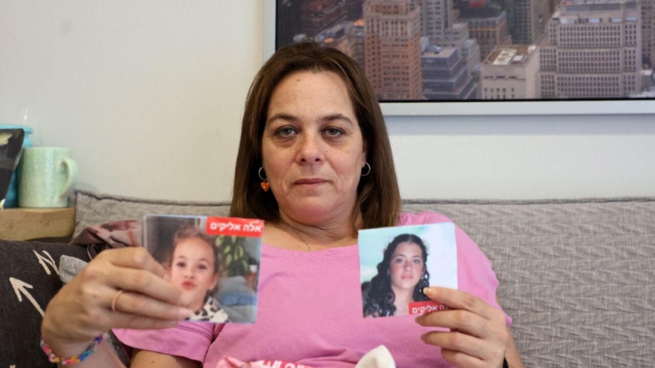 Maayan Zin shows pictures of her daughters Ela, 8, and Dafna, 15, who are believed to be among the hostages  Hamas militants took during the October 7 attack