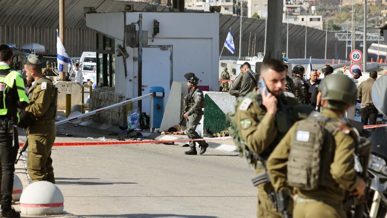 Israeli officers secure the scene after an attack by gunmen on a checkpoint guarding the access to road tunnels linking the occupied West Bank and Jerusalem 