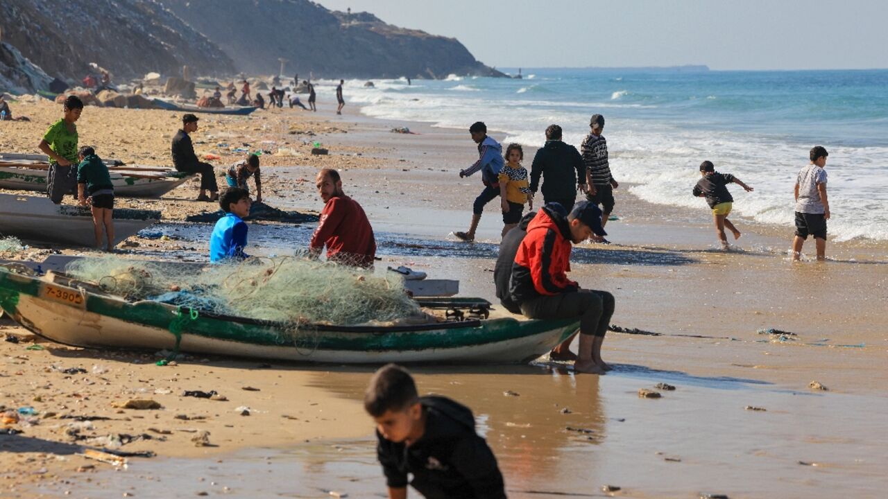 Palestinians flock to Deir el-Balah beach in the central Gaza Strip, taking advantage of a pause in fighting between Israel and Hamas to bathe or fish