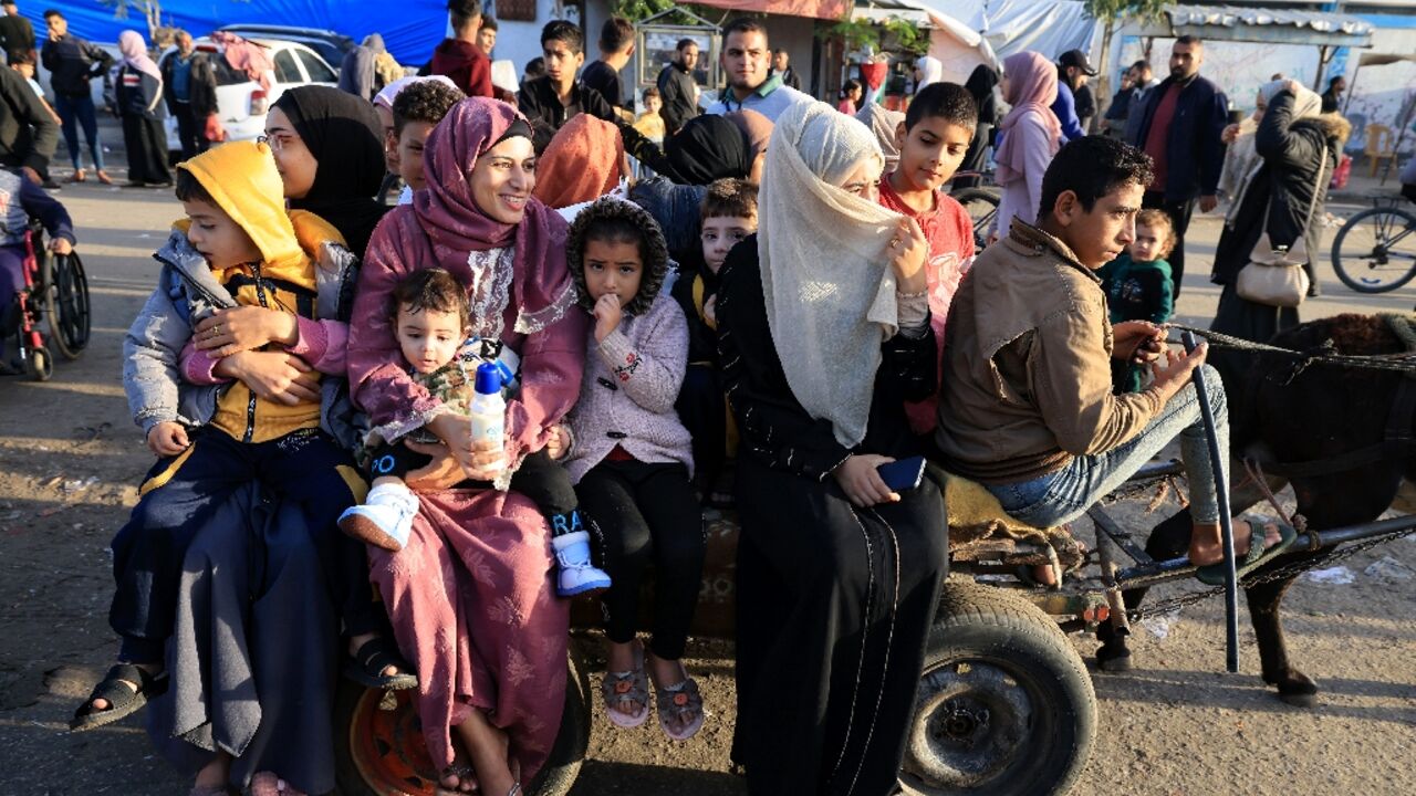 Palestinians who had taken refuge in temporary shelters head home during a pause in fighting in the Gaza Strip