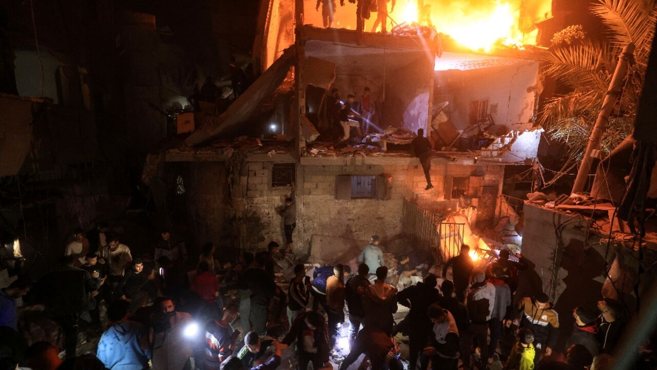 People search for victims in the rubble of a building after a strike on Rafah in southern Gaza