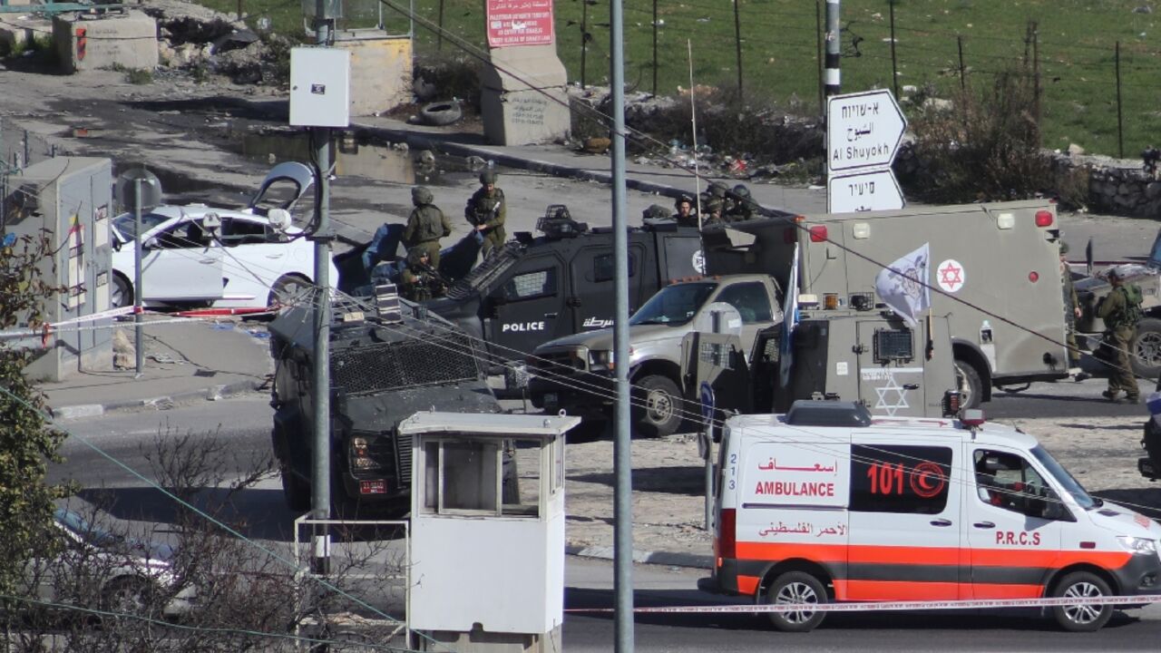Israeli troops cordon off a road junction north of the West Bank city of Hebron after shooting dead a Palestinian motorist they suspected of preparing to attack them