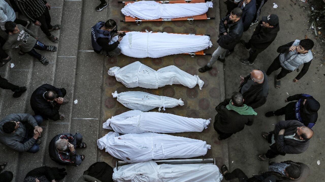 Mourners stand by shrouded bodies of relatives at Khan Yunis's Nasser hospital