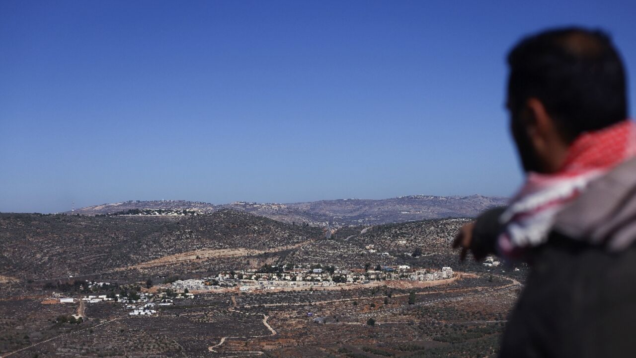 A relative of Palestinian Bilal Saleh, who was shot in the chest while picking olives, points at an Israeli settlement near the village of As-Sawiyah in the occupied West Bank in on November