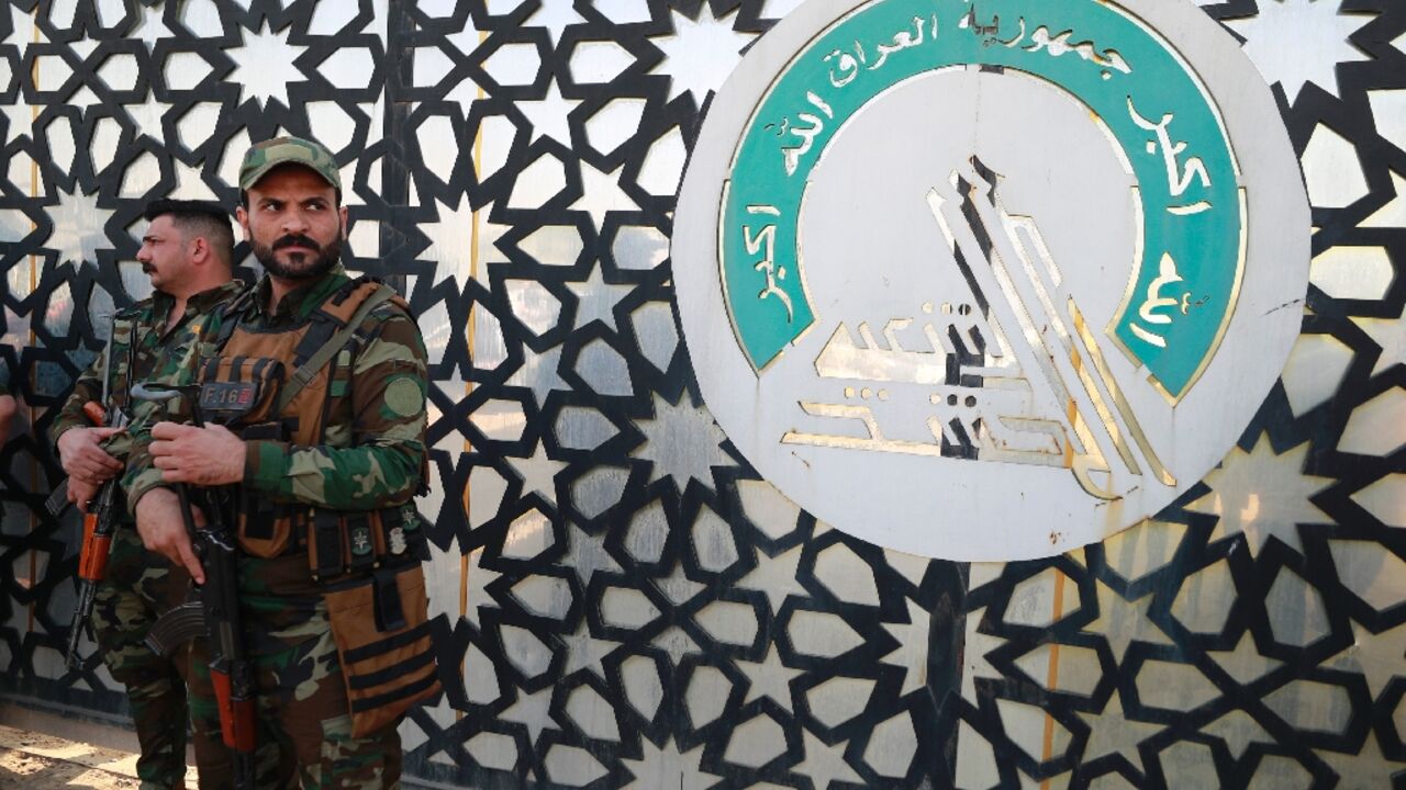 Members of Iraq's Hashed al-Shaabi stand guard at the entrance of their headquarters in Baghdad
