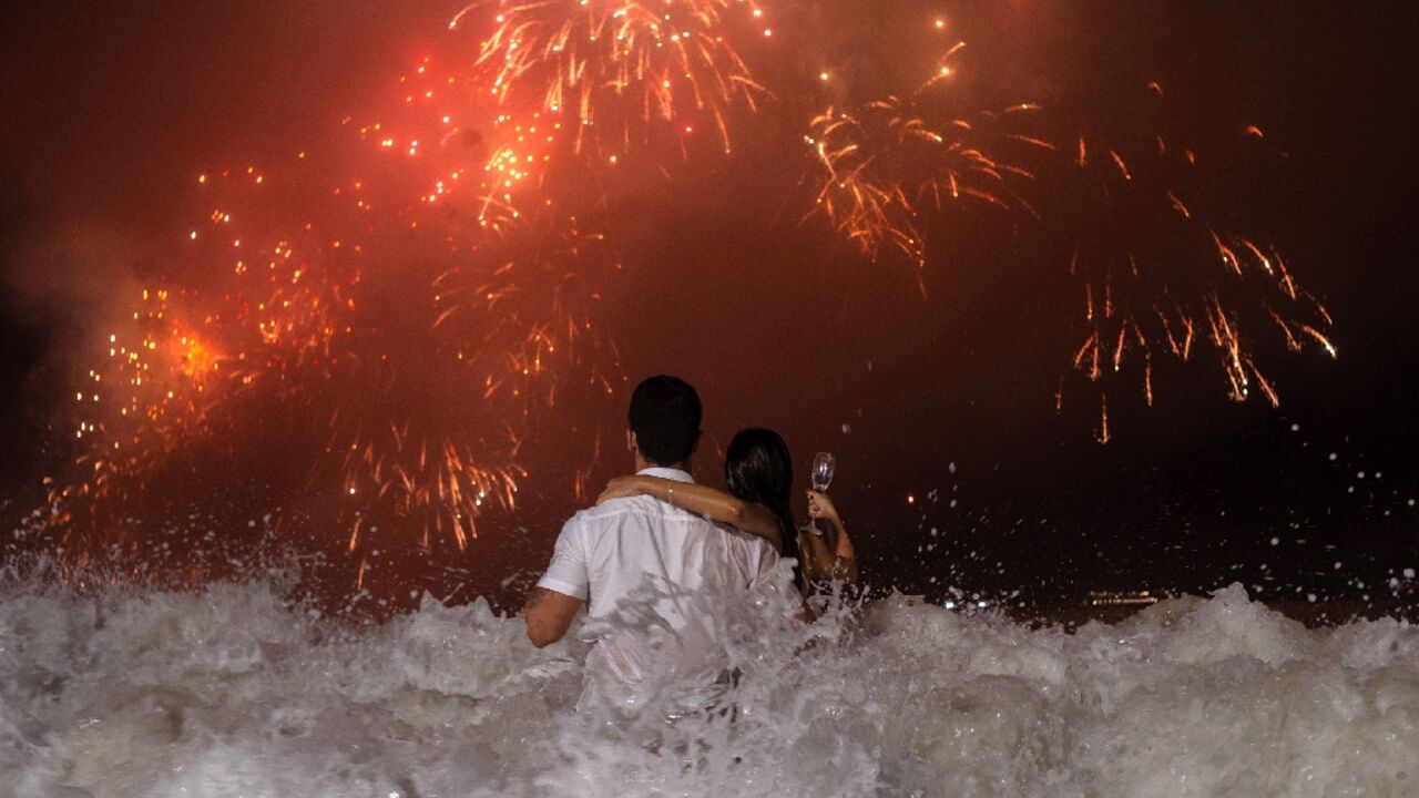 People watch New Year's  fireworks from the water at Rio's Copacabana Beach